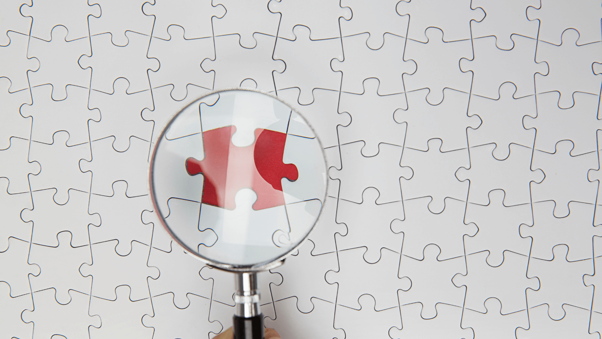 A magnifying glass spotting a different colored puzzle piece