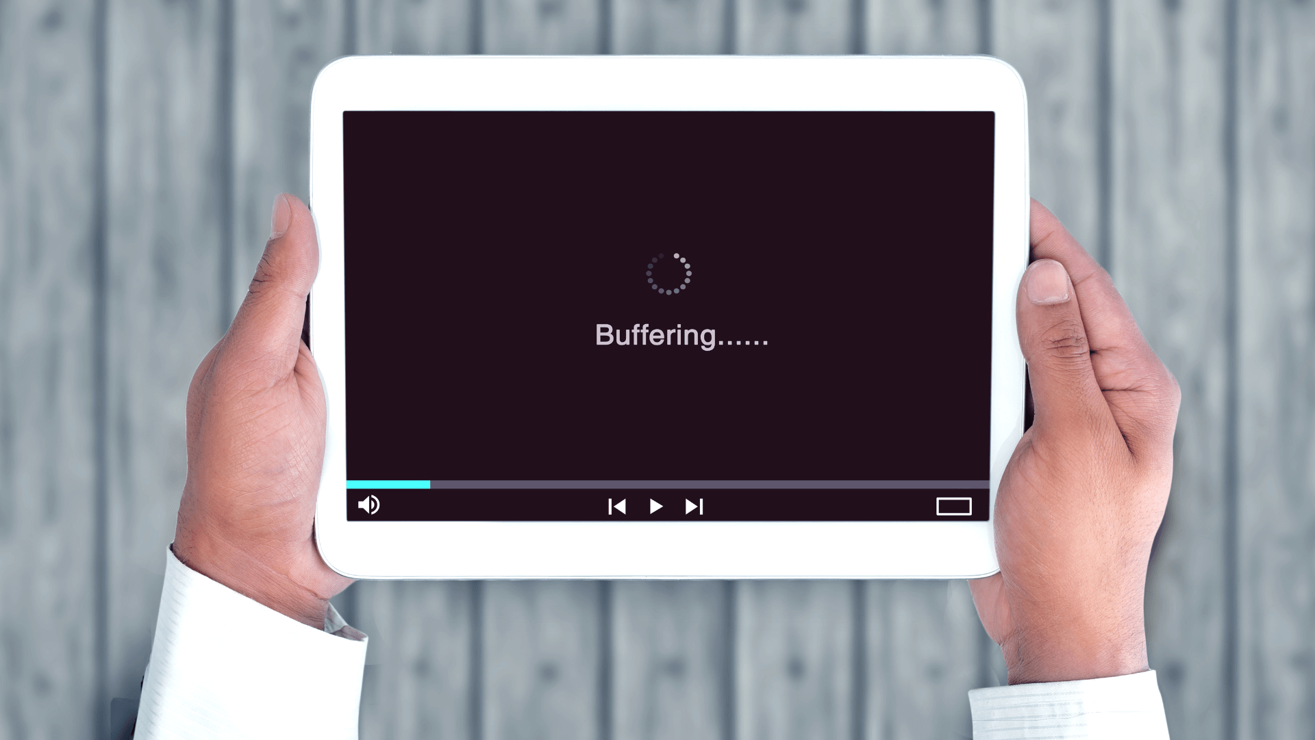 A person holding a tablet displaying a buffering screen