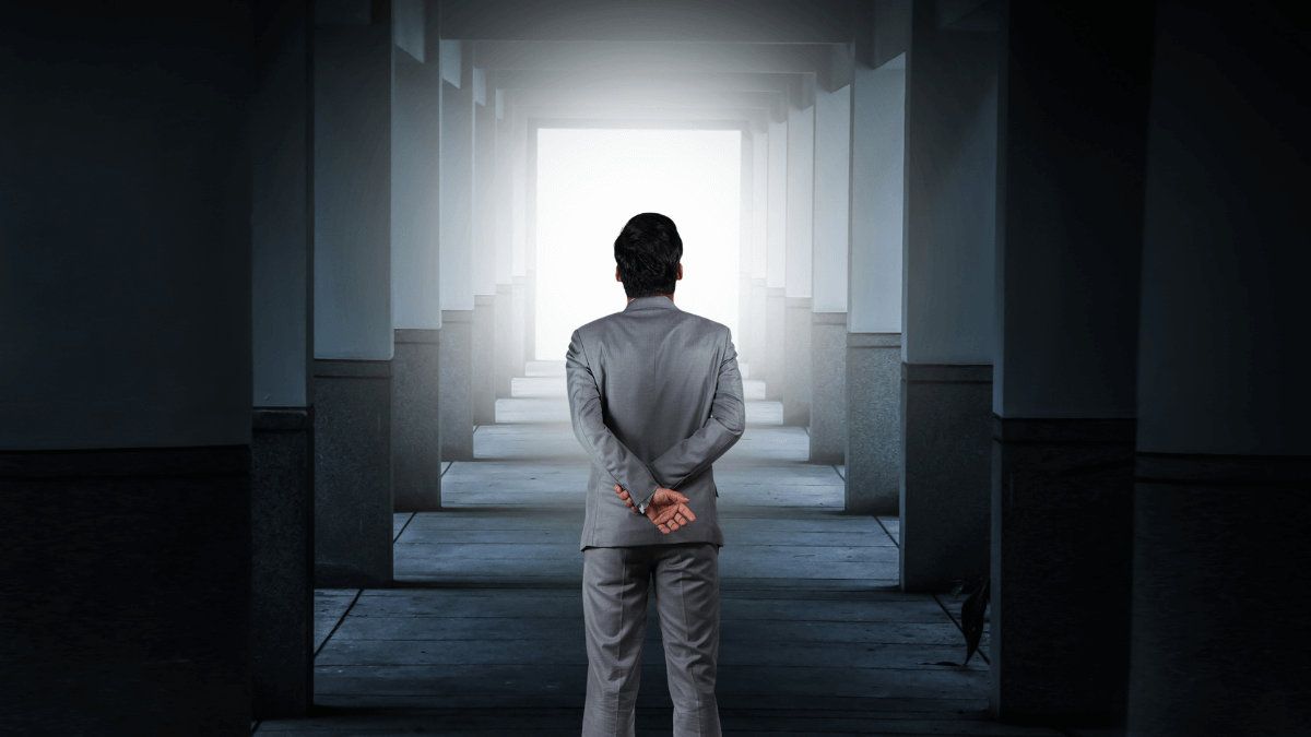 A person standing at the center of multiple pillars while looking far away in front