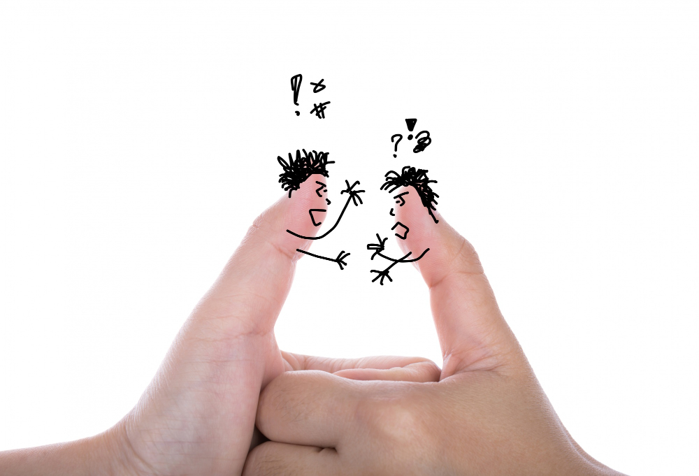 An image of two person's thumbs arguing and competing
