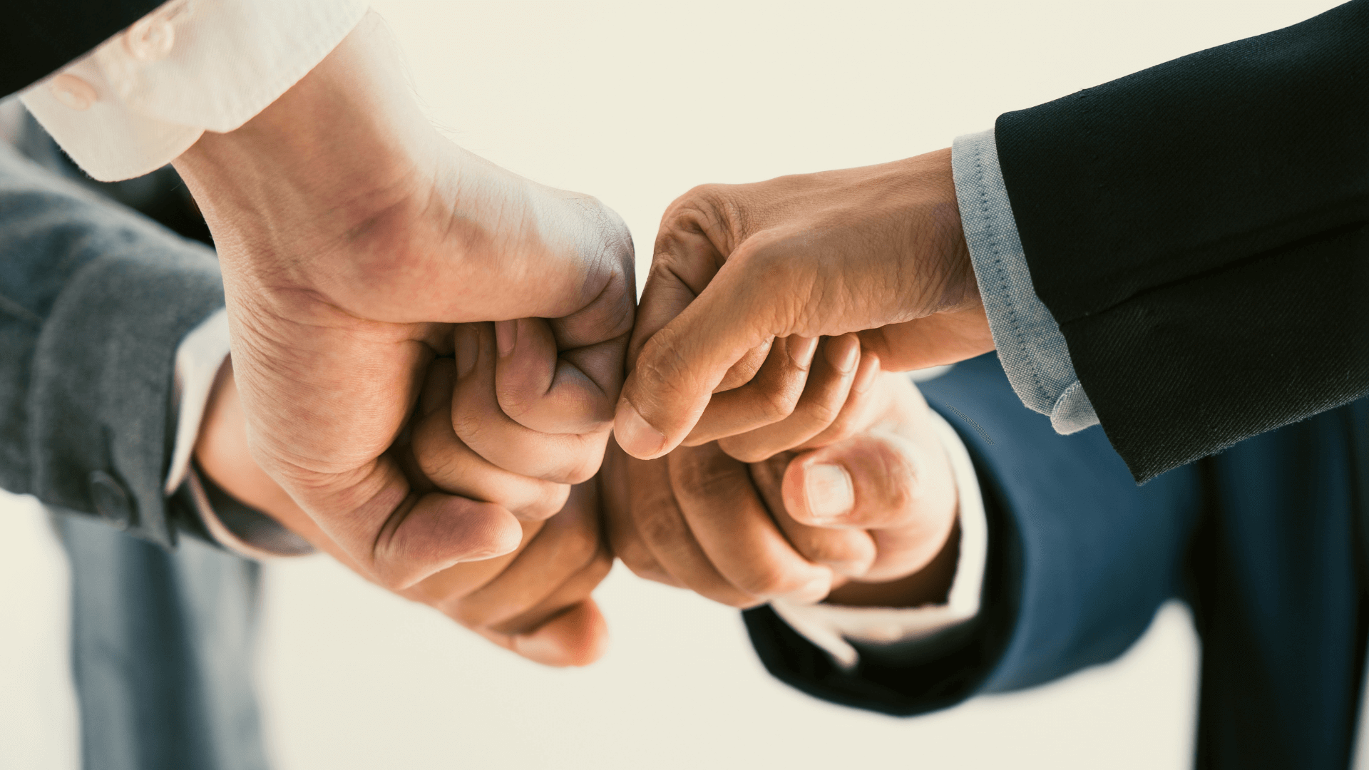 4 people having a fist bump with each other