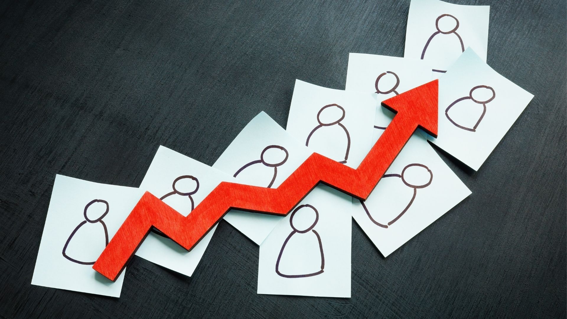 An upward arrow with people-like drawing on a paper on each step