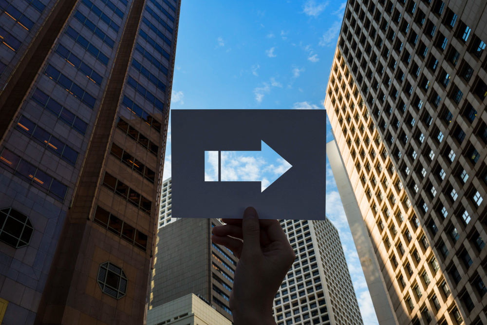 A paper cut arrow pointing on the right side of the person holding it