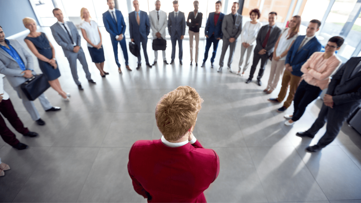 A person in red suit is at the center surrounded by a group of people