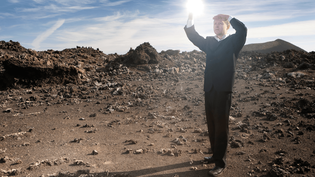 A person standing on a rocky land while looking for something
