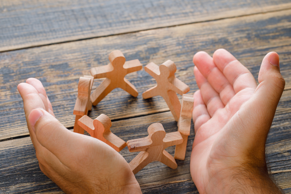 A person's hand barricading a human-like wooden figure