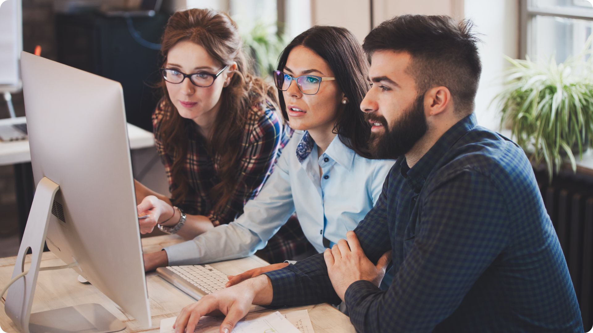 Three people looking at a computer screen