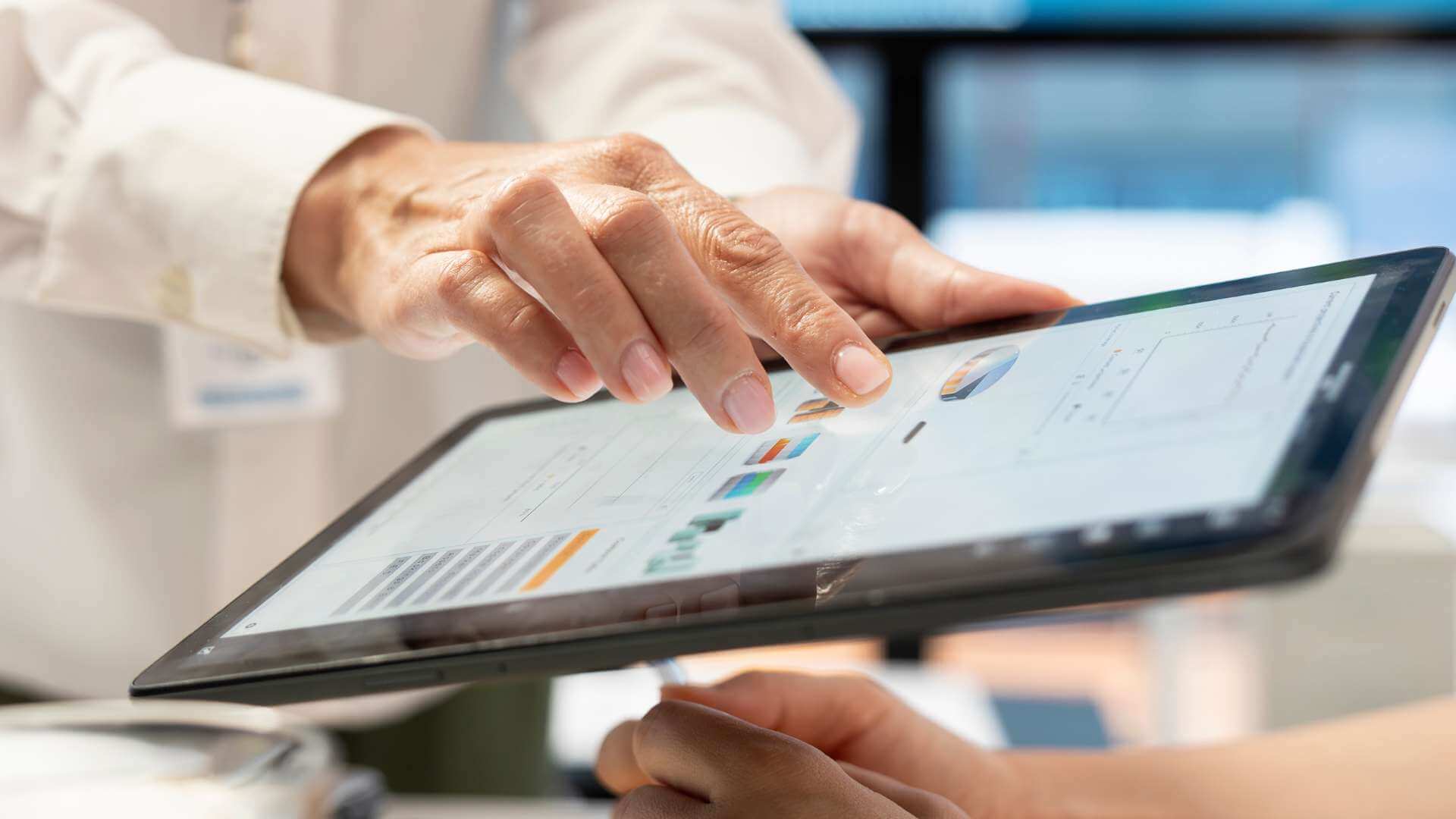 A doctor showing graphs and visuals using a tablet