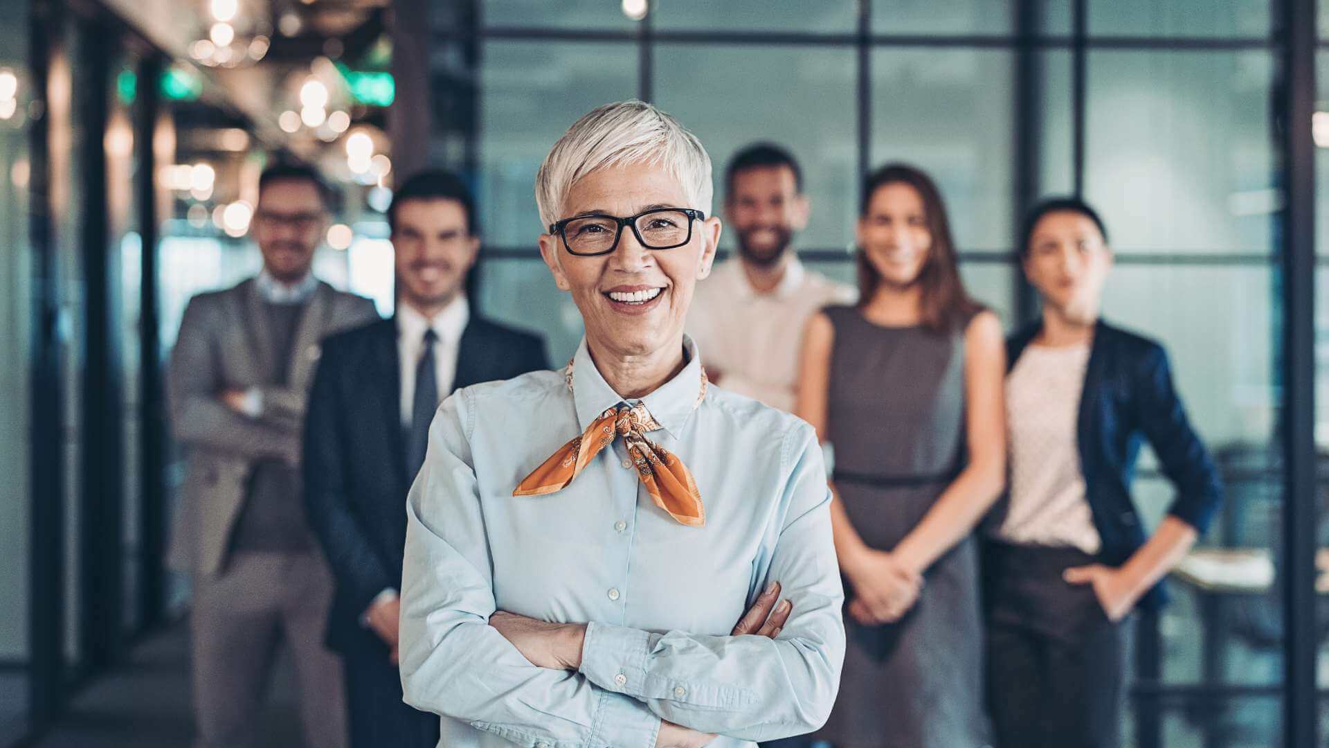 An image of a group of people showing the team's leader in front with her members at the back