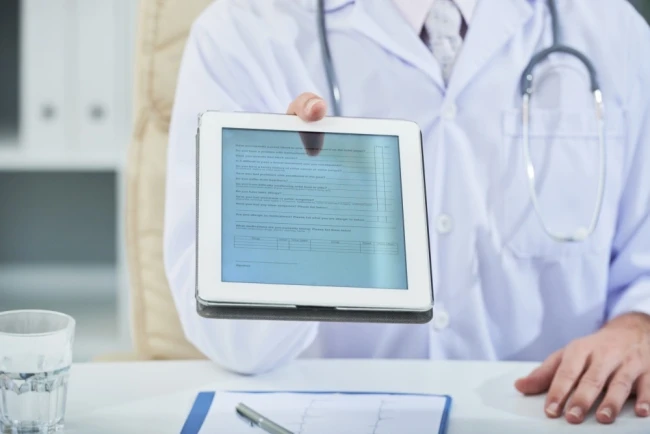 doctor-holding-tablet-with-healthcare-app-open